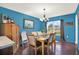 Bright dining room featuring a chandelier, dark wood floors, and a large window at 9291 Geranium Ave, Spring Hill, FL 34606