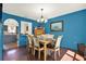 Inviting dining room featuring blue walls, hardwood floors, and stylish chandelier at 9291 Geranium Ave, Spring Hill, FL 34606