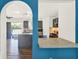 An arched doorway gives way to a modern kitchen with dark gray cabinets and a breakfast bar at 9291 Geranium Ave, Spring Hill, FL 34606