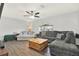 Bright living room showcasing a sectional sofa, hardwood floors, and ceiling fan at 9291 Geranium Ave, Spring Hill, FL 34606