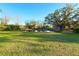 A grassy backyard features a pond and mature trees at 9512 Sunshine Blvd, New Port Richey, FL 34654