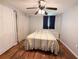 Bedroom with wood-look floors, ceiling fan, and light neutral walls at 9512 Sunshine Blvd, New Port Richey, FL 34654