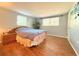 A bedroom with wood floors, and natural light from the two windows at 9512 Sunshine Blvd, New Port Richey, FL 34654