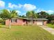 Charming red brick home with a well-manicured lawn and two palm trees in the front yard at 9512 Sunshine Blvd, New Port Richey, FL 34654