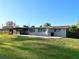 Exterior view of home featuring a screened porch and large backyard at 9512 Sunshine Blvd, New Port Richey, FL 34654