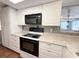 Kitchen showcasing granite counters, stainless steel appliances, and white cabinetry at 9512 Sunshine Blvd, New Port Richey, FL 34654