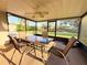 Screened patio features a ceiling fan and views of the yard and pond at 9512 Sunshine Blvd, New Port Richey, FL 34654