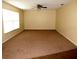 Spacious living room with neutral-toned walls, large window, and plush carpeting at 10020 Vancouver Rd, Spring Hill, FL 34608