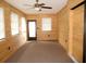 Spacious living room with wood walls, windows, and a ceiling fan at 10020 Vancouver Rd, Spring Hill, FL 34608