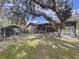 Exterior view featuring a screened pool area, wooden deck, dog kennel, and a spacious backyard, offering ample outdoor space at 10044 Lakeview Dr, New Port Richey, FL 34654