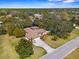 Aerial shot of a home with a long drive and tropical landscaping, and a caged-in pool at 10079 Deer St, Spring Hill, FL 34608