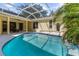 Relaxing screened-in pool with a waterfall feature and an outdoor dining area at 10079 Deer St, Spring Hill, FL 34608