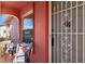 Close-up of the front door with metal security screen and nearby seating on the tiled front porch with decorative columns at 10469 Ireland St, Spring Hill, FL 34608