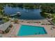 Aerial view of a community pool and lake featuring an idyllic fountain and covered pier at 11140 Carriage Hill Dr # 3, Port Richey, FL 34668