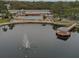 Aerial view of community pool, lake with fountain, pier, building, and palm trees at 11140 Carriage Hill Dr # 3, Port Richey, FL 34668