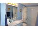 Bathroom featuring a marble-look sink, shower, toilet, framed mirror, and coordinated decor in shades of blue at 11140 Carriage Hill Dr # 3, Port Richey, FL 34668