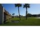 Beautifully landscaped front lawn of a condo community, dotted with palm trees and vibrant greenery at 11140 Carriage Hill Dr # 3, Port Richey, FL 34668