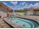 Community pool area featuring a jacuzzi, pool furniture, and a covered patio for relaxation at 11140 Carriage Hill Dr # 3, Port Richey, FL 34668