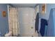 Shower with white tiling, a shower curtain, shower head, and grab bar, designed for accessibility and convenience at 11140 Carriage Hill Dr # 3, Port Richey, FL 34668