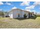Back exterior of home with a screened in porch and well-maintained landscaping at 11257 Frigate Bird Ave, Weeki Wachee, FL 34613