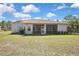 Back exterior of home with a screened in porch and well-maintained landscaping at 11257 Frigate Bird Ave, Weeki Wachee, FL 34613