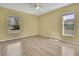 A bedroom with yellow walls, wood-look flooring, and windows at 11257 Frigate Bird Ave, Weeki Wachee, FL 34613