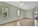 Bright bedroom featuring wood floors, ceiling fan, two windows, and sliding glass door at 11257 Frigate Bird Ave, Weeki Wachee, FL 34613
