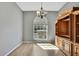 Dining room with wood-look flooring, an elegant chandelier, and a large window for natural light at 11257 Frigate Bird Ave, Weeki Wachee, FL 34613