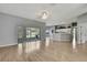 Open floorplan showcasing the living room with sliding glass doors to the screened porch and a view to the kitchen at 11257 Frigate Bird Ave, Weeki Wachee, FL 34613
