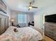 Comfortable bedroom featuring a ceiling fan, bed, and built-in desk at 11723 Foxworth Ln, New Port Richey, FL 34654