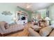 Bright living room featuring hardwood floors, ceiling fans, and a decorative entertainment center at 11723 Foxworth Ln, New Port Richey, FL 34654