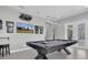 A stylish game room showcasing a unique pool table design and a wall-mounted TV for entertainment at 12399 Gulf Pine Spur, Odessa, FL 33556