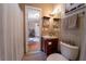 Cozy bathroom with framed cow art, cute decorations, and a door leading to an additional room at 13024 Mohican Ave, New Port Richey, FL 34654