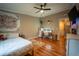Bright bedroom featuring wood floors, ceiling fan, and a charming vanity area for getting ready at 13024 Mohican Ave, New Port Richey, FL 34654