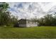 Exterior view of home with green lawn, mature trees, and neutral-toned siding at 13024 Mohican Ave, New Port Richey, FL 34654