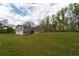 View of the home's exterior from the back, showing a deck and spacious yard at 13024 Mohican Ave, New Port Richey, FL 34654