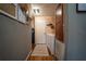Hallway with washer and dryer hookups, water softener, storage, and warm-toned walls and wood floors at 13024 Mohican Ave, New Port Richey, FL 34654