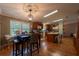 Open kitchen and dining area featuring wood floors, light fixtures, and many windows at 13024 Mohican Ave, New Port Richey, FL 34654