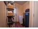 Utility room with shelving, water softener, and an exterior door leading to the outside at 13024 Mohican Ave, New Port Richey, FL 34654
