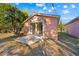 View of peach building exterior, featuring a sliding glass door and a concrete patio at 16422 Monteverde Dr, Spring Hill, FL 34610