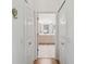 Bathroom entryway with dual closets, tiled floors, vanity, and neutral color palette at 18129 Baywood Forest Dr, Hudson, FL 34667