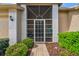 Inviting front porch with tiled floor, screen door and decorative brick accents at 18129 Baywood Forest Dr, Hudson, FL 34667
