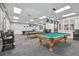 This game room features three billiard tables with ample lighting and comfortable seating at 18129 Baywood Forest Dr, Hudson, FL 34667