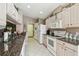 Bright kitchen features white cabinets, stainless appliances, tile floors, granite countertops, and a doorway at 18129 Baywood Forest Dr, Hudson, FL 34667
