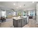 Bright open-concept living area featuring a kitchen island, living room, and dining space with modern lighting at 19742 Sea Glass Cir, Land O Lakes, FL 34638