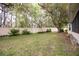 A well-maintained backyard featuring a lush green lawn and mature trees at 2641 Royal Ridge Dr, Spring Hill, FL 34606