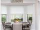 A cozy breakfast nook is in a bay window with a round table and gray rolling chairs at 2641 Royal Ridge Dr, Spring Hill, FL 34606
