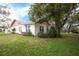 Charming exterior view of home with mature trees, lush landscaping, and a well-manicured lawn at 2641 Royal Ridge Dr, Spring Hill, FL 34606