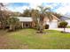 Inviting single-story home featuring a well-manicured lawn, mature trees, and a spacious front yard at 2641 Royal Ridge Dr, Spring Hill, FL 34606
