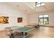 Game room with ping pong tables, neutral walls, laminate floors, modern abstract art and natural light at 2641 Royal Ridge Dr, Spring Hill, FL 34606